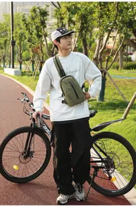 Asian male model wearing a stylish olive green nylon sling bag for outdoor cycling.