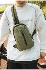 Close-up of olive green nylon outdoor sling bag worn by a male model during outdoor cycling