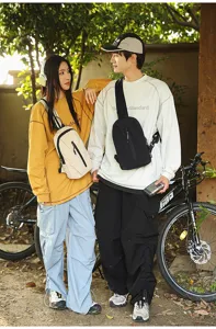 Couple wearing outdoor nylon sling bags in a scenic garden with a bicycle background