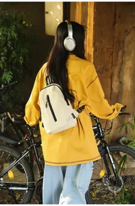 Young woman wearing a functional beige nylon outdoor sling bag for urban cycling
