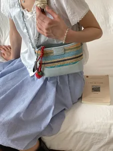 Schicke Sommer-Strandtasche aus buntem Geflecht mit süßem Erdbeer-Anhänger am Band.