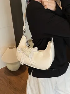 Elegante cremeweiße Hobo-Tasche aus geöltem Leder mit Perlenherz-Anhänger und Schleife