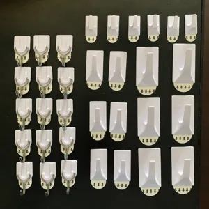 Varietà di ganci a muro autoadesivi bianchi in diverse dimensioni per cucina e bagno