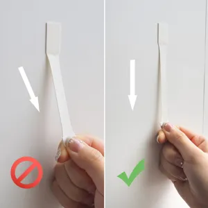 Primo piano che mostra il metodo di trazione verticale corretto per strisce adesive rimovibili.