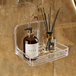 Close-up of a clear acrylic wall-mounted shelf with drainage holes for soap and storage