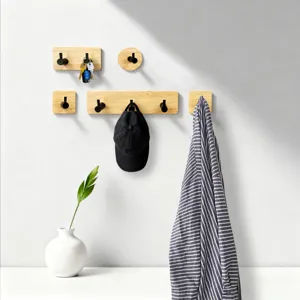 Ganci da parete in legno con pomelli metallici neri per un arredamento moderno e pratico.