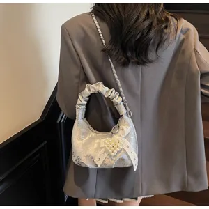 Vue détaillée d'un sac hobo plissé argenté avec nœud en perles et motifs numériques