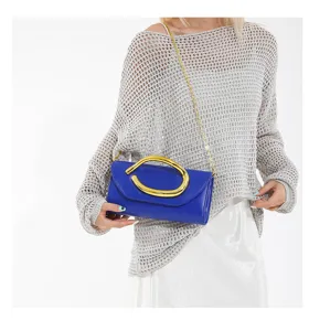 Elegante blaue Abend-Clutch-Tasche mit übergroßem Goldgriff und Kettenriemen-Detail
