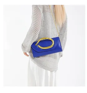 Nahaufnahme einer leuchtend blauen Abendtasche mit elegantem goldener Schulterkette