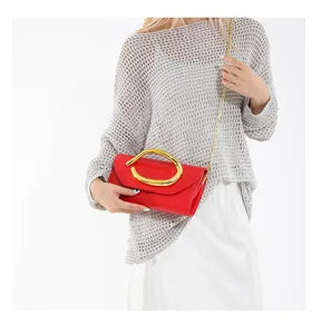 Modell mit roter Abendtasche, goldener Rundgriff und eleganter Kettenschultergurt