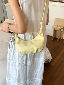 Elegante bolso de media luna plisado amarillo con correa para atuendos de verano.