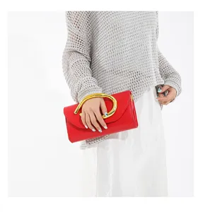 Nahaufnahme einer eleganten roten Abendtasche mit ovalem goldfarbenem Metallgriff