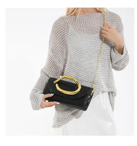 Detailansicht der eleganten schwarzen Abendclutch mit skulpturalem Goldgriff