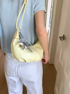 Bolso de hombro plisado amarillo pálido de verano con un elegante colgante de estrella
