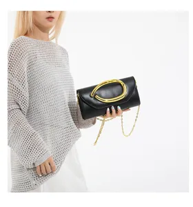 Elegante schwarze Abendhandtasche aus Leder mit goldener Kette, von einem Model präsentiert