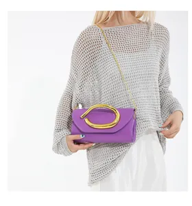 Elegante lila Abendtasche mit klobigem goldfarbenem Metallgriff und Kettenriemen