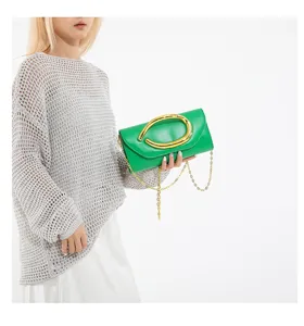 Vibrante grüne Abendclutch mit markanter goldener Hardware und filigranem Kettenriemen-Detail