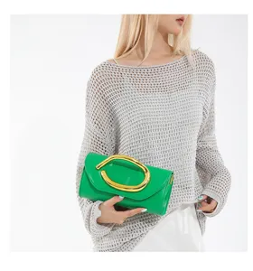 Modell mit einer leuchtend grünen Abendtasche mit einem markanten goldenen Metallgriff