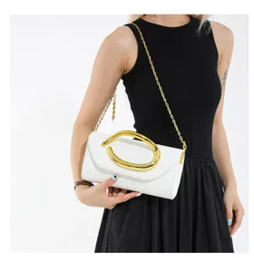 Detailansicht der weißen Abendtasche mit markantem goldfarbenem Rundgriff und Kette
