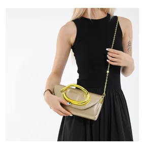Elegante champagnerfarbene Abend-Clutch mit Goldgriff und Kette am Modell