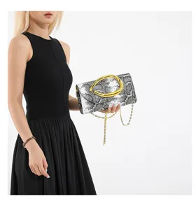 Detailansicht einer sehr stilvollen Abend-Clutch mit Schlangenmuster und Goldkette