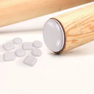 Close-up detail of durable resin furniture slider pad on wooden leg, smooth floor protector.