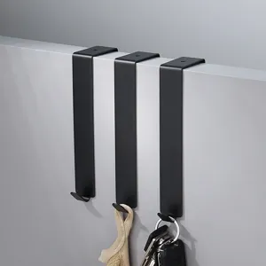 Over the door hook detail view, black metal cabinet hanger for clothes and keys storage.