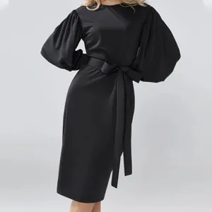 Elegant black midi dress featuring voluminous lantern sleeves and a flattering waist belt.