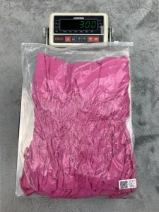 Detailed view of the pink strapless smocked dress packaged in a clear protective bag.
