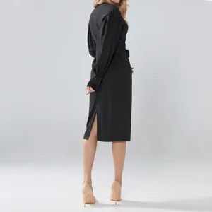 Back view detail of black plus-size midi dress featuring bishop sleeves, belt, and side slit.