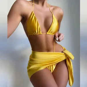 Bikini halter giallo lucido effetto seta con sarong coordinato in primo piano