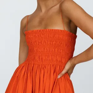 Orange spaghetti strap gathered bodice dress detail, high waist smocked summer dress close-up.