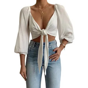 Sexy white deep V-neck long sleeve tie front crop top paired with classic blue jeans.