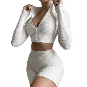 Detailed view of the textured long sleeve zip crop top and matching fitness shorts outfit.