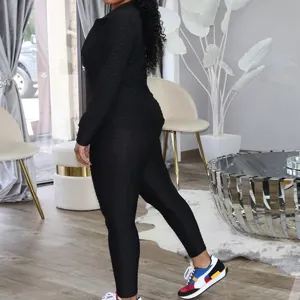 Detail view of women black textured long sleeve jacket and leggings activewear fitness set