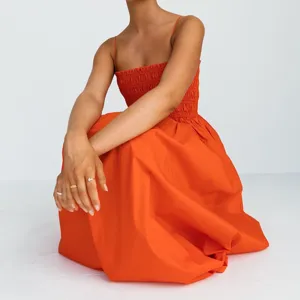 Detailed view of women orange strapless smocked high waist spaghetti strap midi summer dress detail.