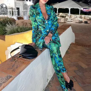 Stylish women's two-piece suit set featuring a vibrant green and blue tropical leaf print blazer.