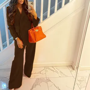 Completo blazer monopetto marrone scuro e pantaloni larghi, elegante dettaglio di stile.