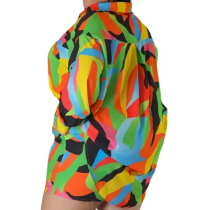 Dettaglio ravvicinato della camicia a maniche lunghe e dei pantaloncini con stampa astratta.