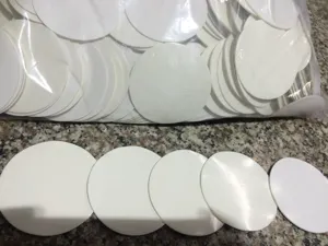 Detailed view of round white strong double-sided adhesive discs for hook suction cup use.