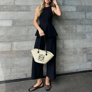 Full-body detail shot of an elegant black sleeveless peplum top and wide-leg pants set