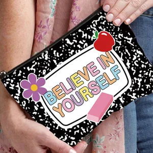 Detailed view of a canvas pouch with 'Believe in Yourself' inspirational quote and apple graphic.
