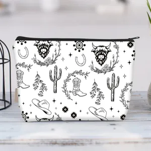 Large canvas makeup bag with Highland cow and western patterns on a wooden surface.