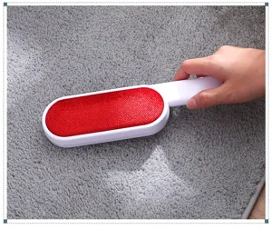 Double sided lint remover brush detail showing the red fabric surface and white handle.