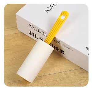 Lint roller with yellow handle and tearable paper roll for clothes hair and dust removal detail.