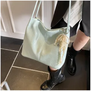Detail of light blue large capacity tote bag with pearl bow charm and wrinkled texture