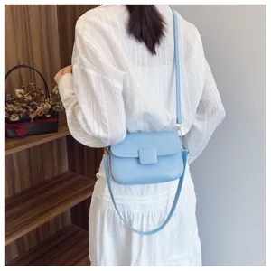 Stylish light blue textured flap crossbody bag shown being worn with white shirt