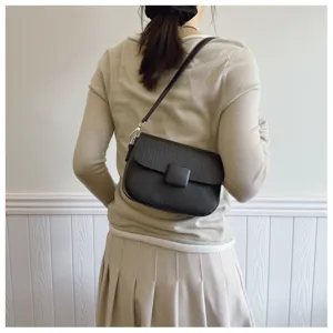 Classic black retro flap crossbody bag styled on a female model in a minimal setting