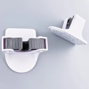 Dettaglio supporto per scopa e mocio, gancio a parete bianco con impugnatura in silicone grigio.