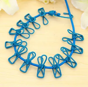 Portable outdoor clothesline detail showing blue elastic rope with metal clips for travel laundry drying.